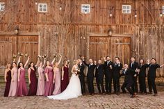 a group of people standing next to each other in front of a wooden building with doors