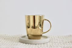 a golden cup sitting on top of a white plate