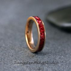 a gold ring with red glitter in it