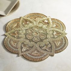 an intricately designed doily sits on a table next to a cell phone and wallet