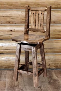 a wooden chair sitting on top of a hard wood floor next to a log wall