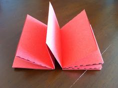 two folded red paper on a wooden table