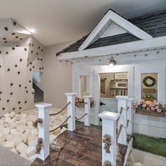 a room with white walls and wooden floors, decorated with fake grass on the floor