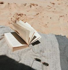 an open book sitting on top of a blanket