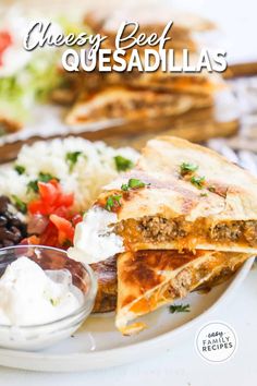 cheese beef quesadillas on a plate with salsa and sour cream