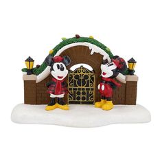 a mickey and minnie mouse figurine set in front of a christmas arch with lights