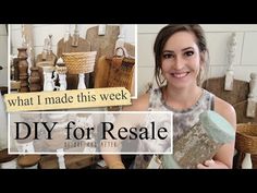 a woman holding up a piece of wood in front of some baskets and other items