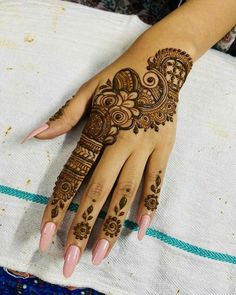 a woman's hand with henna tattoos on it