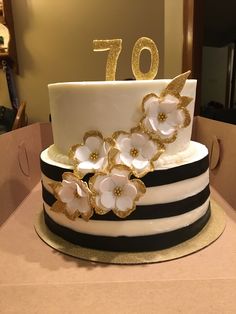 a white and black cake with flowers on top