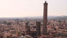 an aerial view of a city with tall towers and buildings in the foreground,