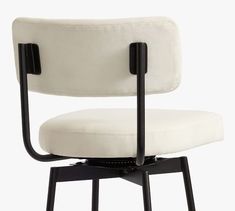 a white chair with black metal legs and a cushion on the armrests, viewed from the front