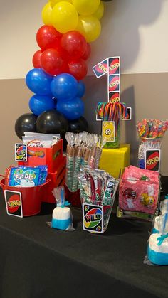 a table with balloons and candy on it