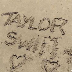 two hearts drawn in the sand with words taylor and swift written on it's side