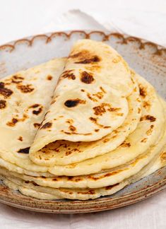 a plate filled with tortillas sitting on top of a table