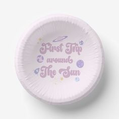 a pink paper plate with the words first trip around the sun written in purple on it