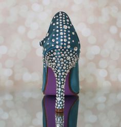 a pair of blue high heeled shoes sitting on top of a table