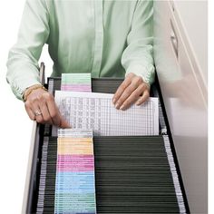 a woman is sitting at a desk with some papers in her lap and holding onto a binder