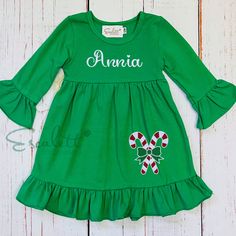 Personalized green ruffle long-sleeved dress with an embroidered candy cane on the bottom of the dress. The dress can be customized with your child's first name or three initials for the monogram of your choice. In the message to the seller, please include the child's first name OR monogram. If you want a monogram, please include the initials in the traditional monogram order: FIRST, last, MIDDLE. The monogram will be stitched in the order provided in the message to the seller. *CARE INSTRUCTIONS* Machine Wash COLD & HANG DRY. We recommend turning it inside before washing it to keep your garment looking great. Cute Long Sleeve Festive Holiday Dress, Cute Long Sleeve Holiday Dress For Festive Occasion, Fitted Long Sleeve Ruffle Holiday Dress, Fitted Long Sleeve Holiday Dress With Ruffles, Cute Long Sleeve Christmas Holiday Dress, Green Long Sleeve Christmas Dress, Holiday Green Long Sleeve Dresses, Green Long Sleeve Dress For Holiday, Festive Long Sleeve Holiday Dress With Ruffles