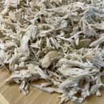 a pile of shredded white paper sitting on top of a wooden cutting board