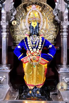 an idol is displayed in front of a golden statue