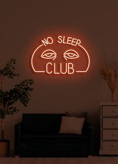 a neon sign that says no sleep club in front of a black couch with a potted plant