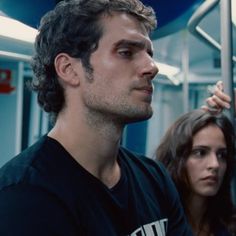 a man standing next to a woman on a train