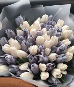 a bouquet of white and purple tulips