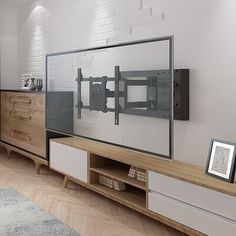 a large flat screen tv sitting on top of a wooden entertainment center in a living room