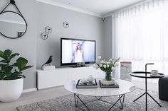 a living room with white furniture and a flat screen tv