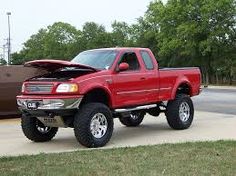 a red pick up truck parked in front of a building