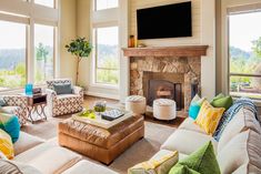 a living room filled with lots of furniture and a flat screen tv mounted above the fireplace