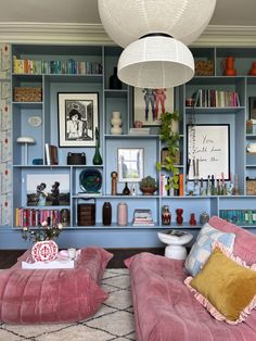 a living room filled with lots of furniture and bookshelves covered in pictures on the wall