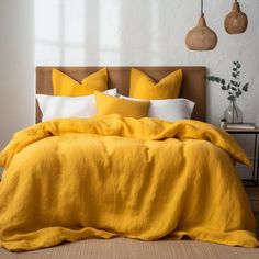 a bed with yellow linens and white pillows