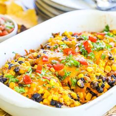 a casserole dish with corn, black beans, and salsa in it on a table