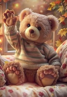 a teddy bear sitting on top of a bed in front of a window with fall leaves