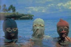 three people in the water wearing masks and goggles