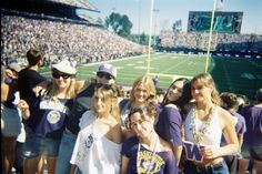 a group of young people standing on top of a football field in front of a crowd