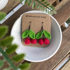 crocheted cherry drop earrings on a plate