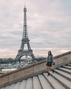 a woman standing in front of the eiffel tower