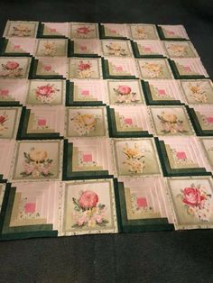 a quilted table topper with flowers on it and green border around the edges