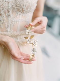 a close up of a person wearing a dress and holding something in their hand with both hands