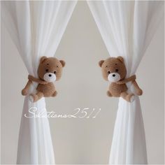 two teddy bears are peeking out from behind the curtains