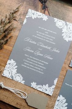 the wedding stationery is laid out on a wooden table