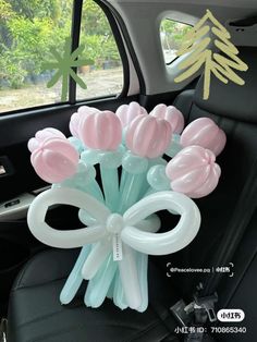 a bunch of balloons sitting in the back seat of a car with bows on them