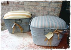 two buckets sitting next to each other on top of a cement floor near a brick wall