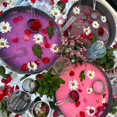 there are flowers and candles in the trays on the table with pink frosting