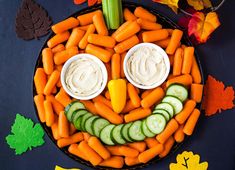 a plate with carrots, cucumbers and celery in the shape of a face