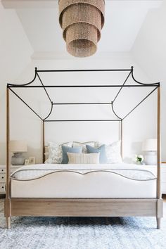 a bedroom with a canopy bed and pillows on the bottom row, along with two nightstands