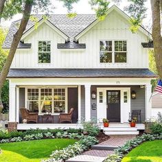 a white and gray house with an american flag in the front yard