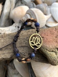 "The lovely and enchanting lotus flower that reminds us to rise up, stay strong and persevere. A thoughtful and loving gift for a friend or loved one facing life challenges or who has risen to the occasion and has fought bravely and courageously. The gorgeous 6mm Sodalite stones are so beautiful paired with the earth toned DZI Agate stones which lend an organic quality to this hand knotted macrame bracelet. The deep dark brown cotton cord really sets off these colors perfectly. The wood beads on Adjustable Bracelet For Friendship, Adjustable Bracelets For Friendship, Adjustable Nature-inspired Bracelet With Round Beads, Spiritual Braided Bracelets With Round Beads For Meditation, Adjustable Inspirational Jewelry For Meditation, Spiritual Braided Bracelets With 8mm Beads For Friendship, Adjustable Nature-inspired Beaded Bracelets, Adjustable Holistic Beaded Bracelets As Gift, Spiritual Flower-shaped Bracelets For Gift